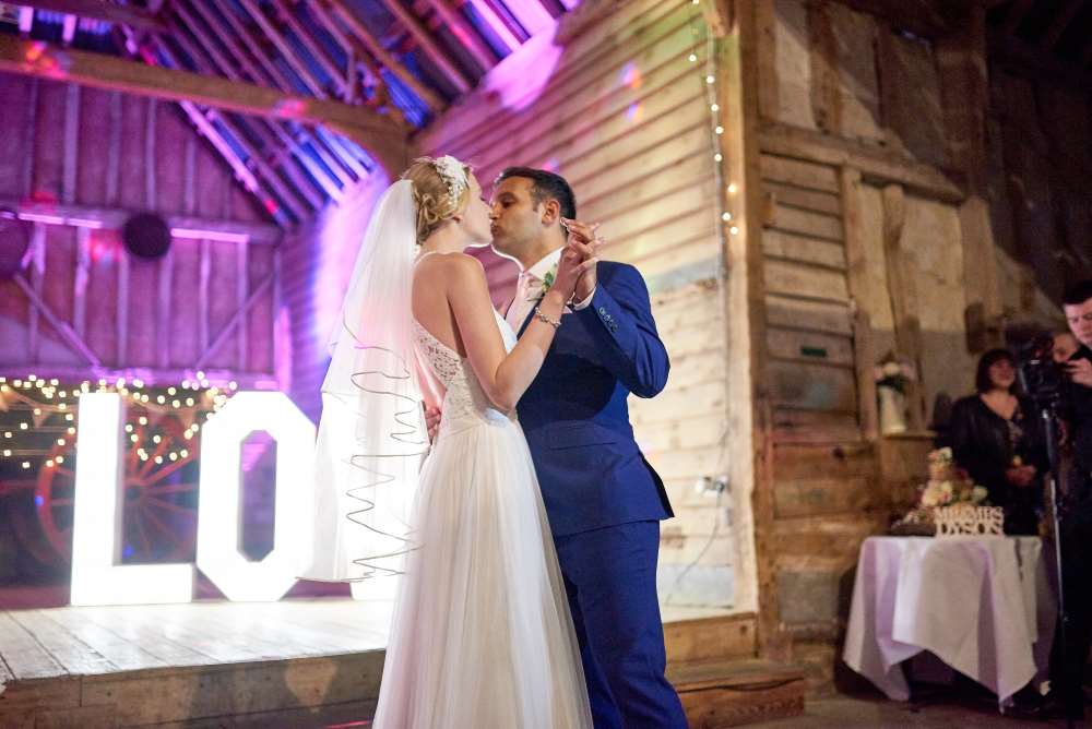 First Dance at Preston Priory Barn with LOVE letters in the background