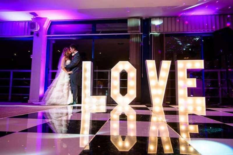 wedding couple standing next to love letters