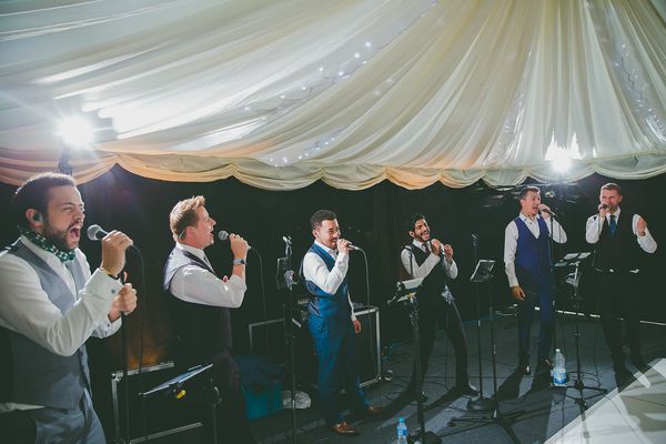 Acafellas performing at a wedding in a Marquee