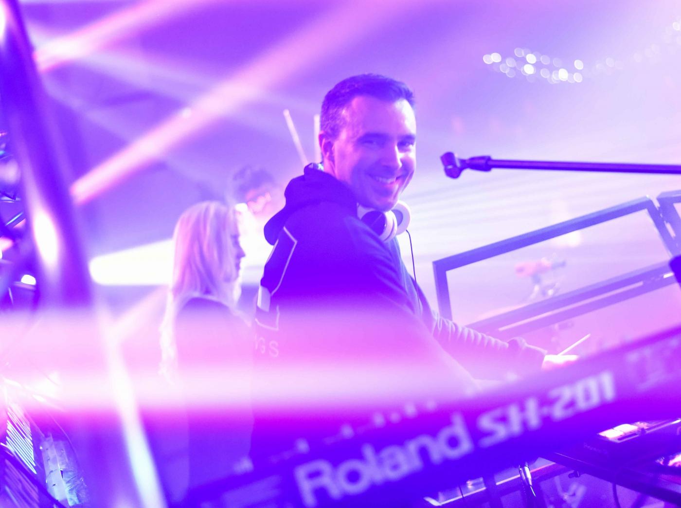 DJ Eliot White playing on stage with violet lighting