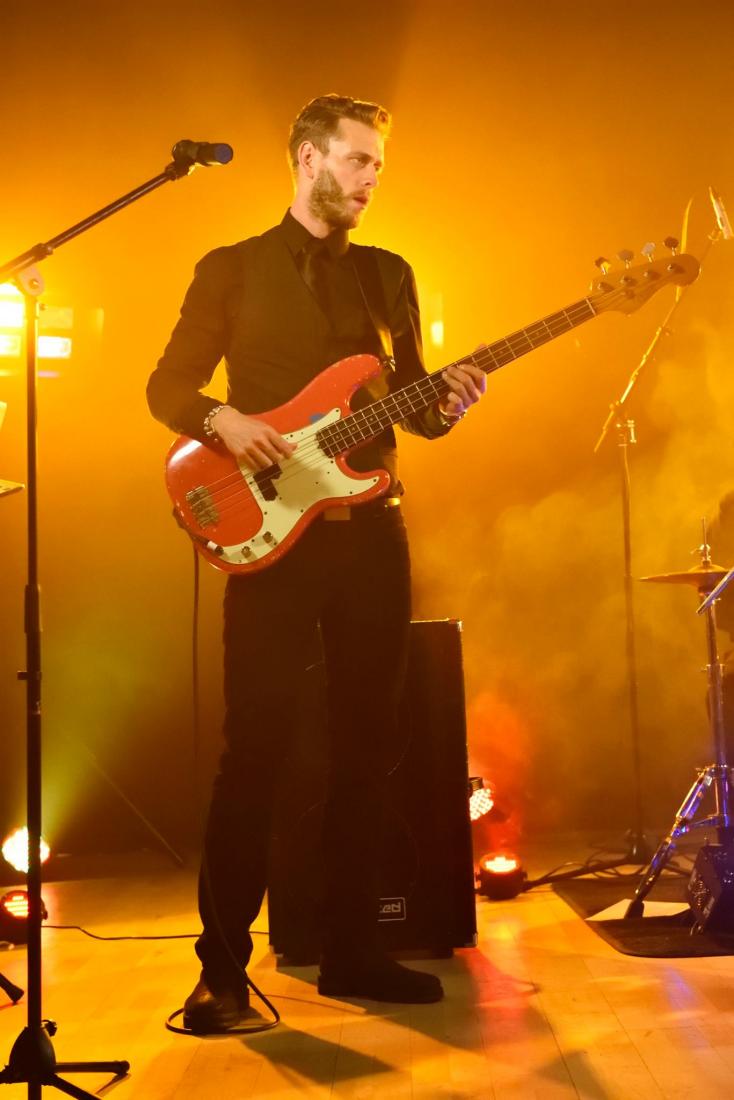 AZURE Band guitarist on stage wit bright orange lights